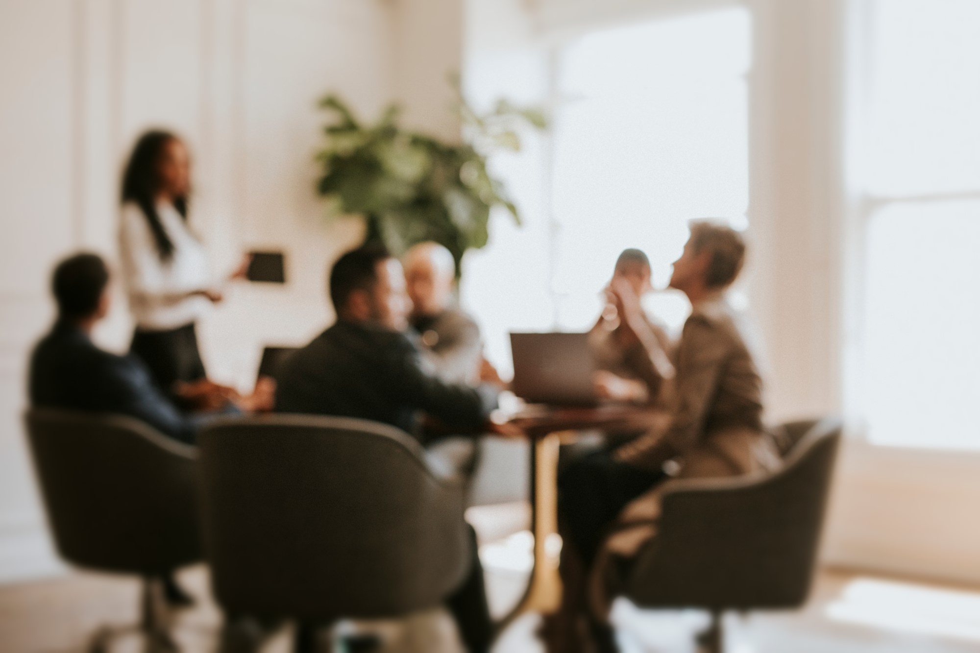 A team in a meeting around a table in a sunlit office