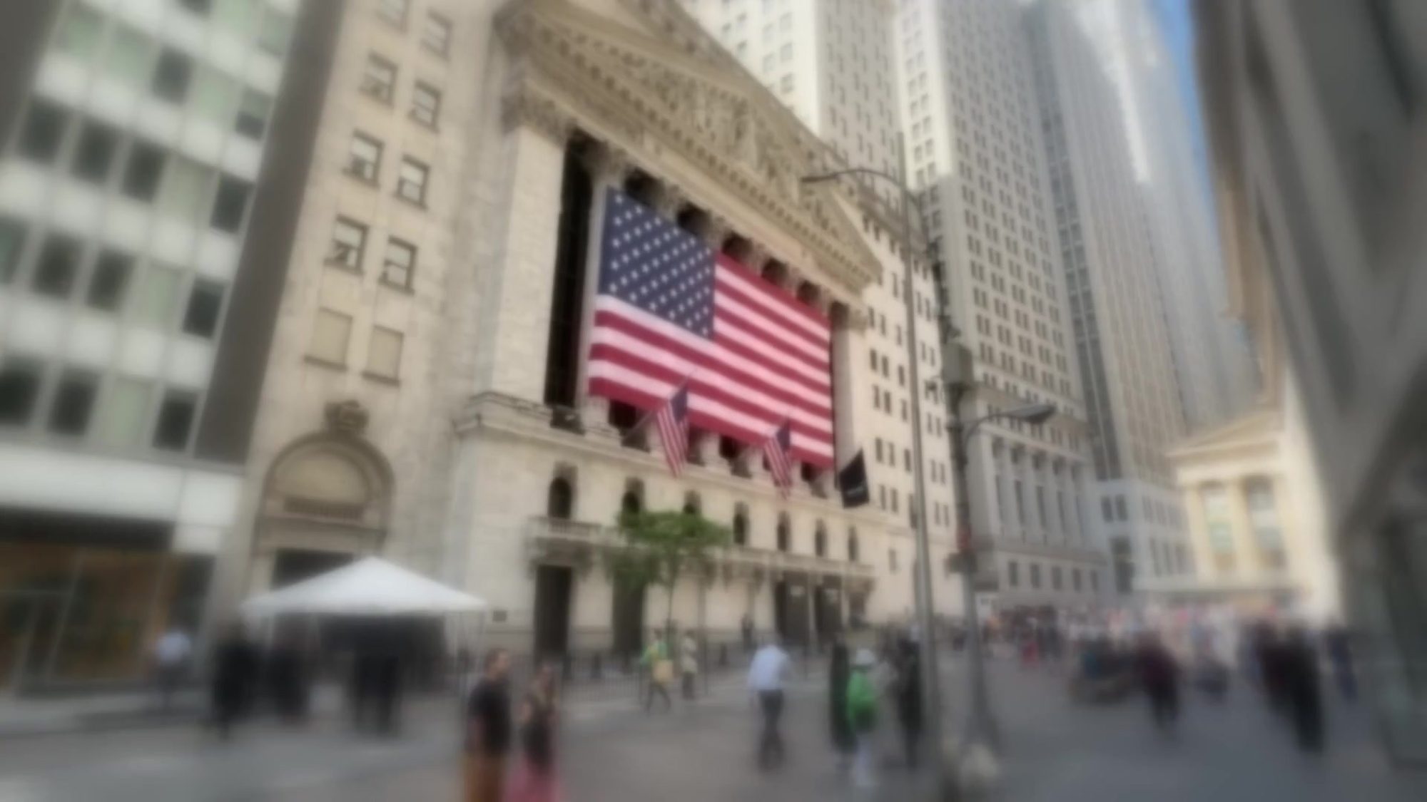 The New York Stock Exchange with a large American flag, out of focus
